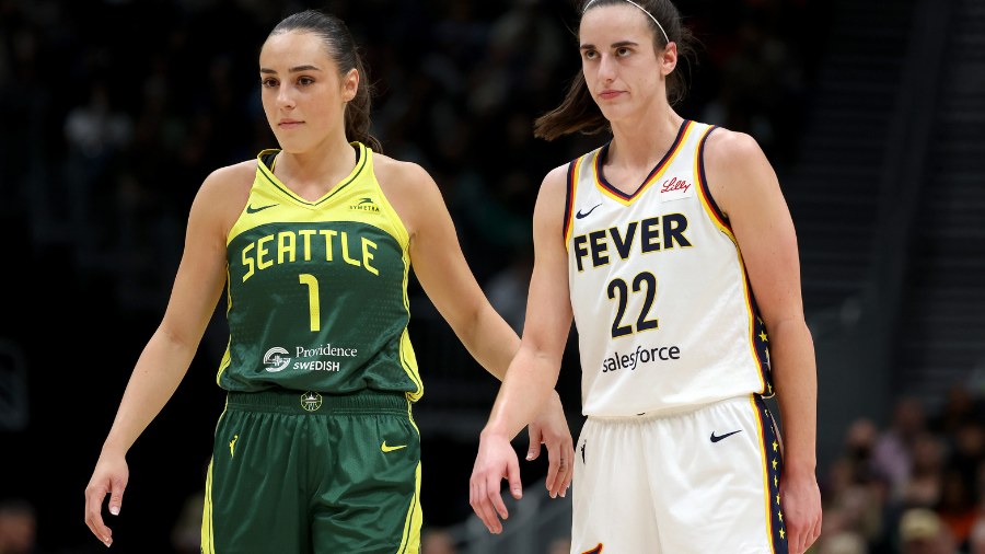 Image: Nika Muhl of the Seattle Storm, left, and Caitlin Clark of the Indiana Fever watch the action while a player shoots a free throw during their matchup at Climate Pledge Arena in Seattle on Wednesday, May 22, 2024.